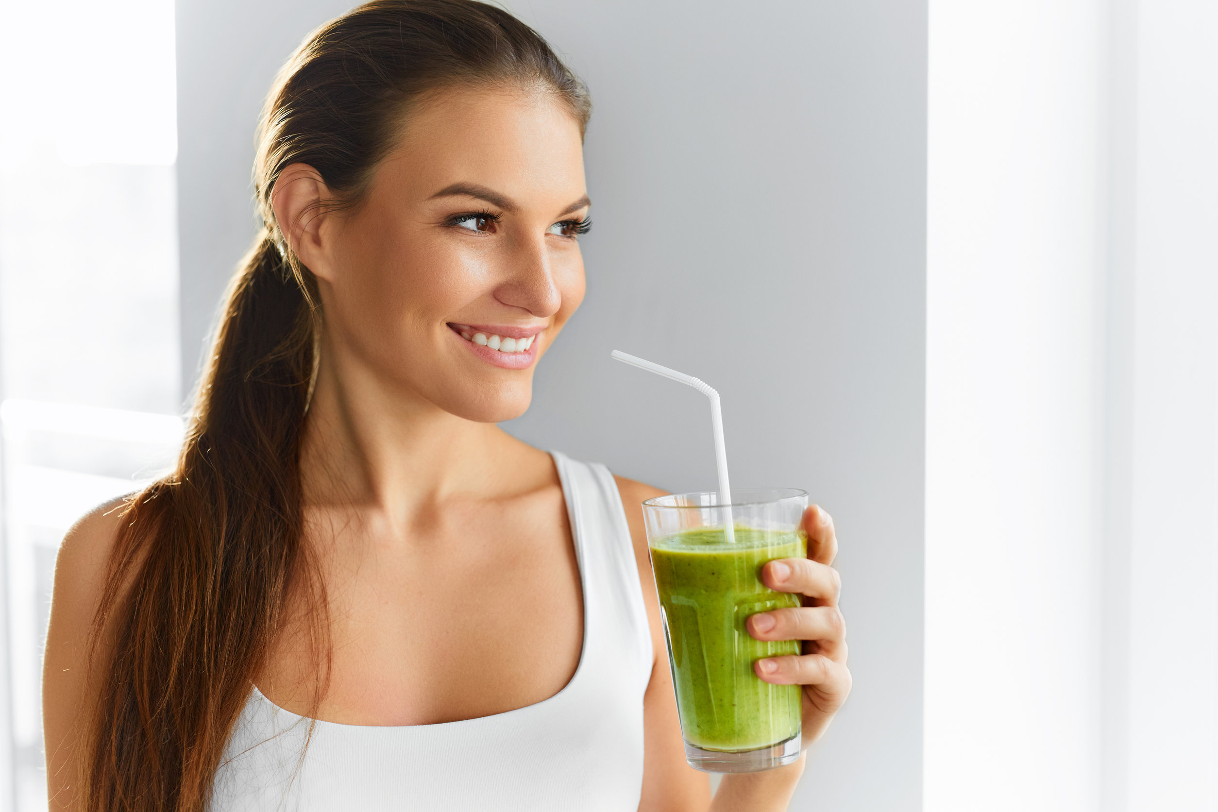 girl drinking supreme green cold pressed cold-pressed juice with straw