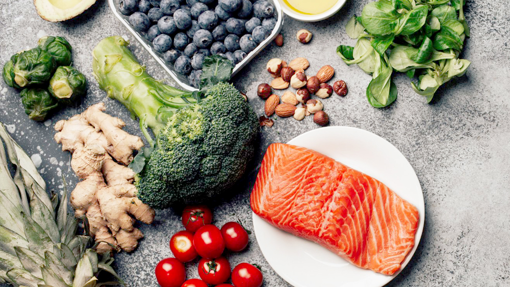 paleo diet meal with salmon broccoli cherries grapes and other healthy diet foods