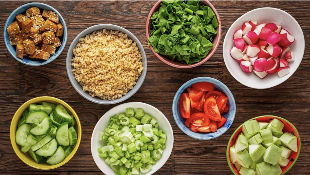 Eight bowls of healthy fruits and vegetables are displayed to demonstrate how to eat healthily.